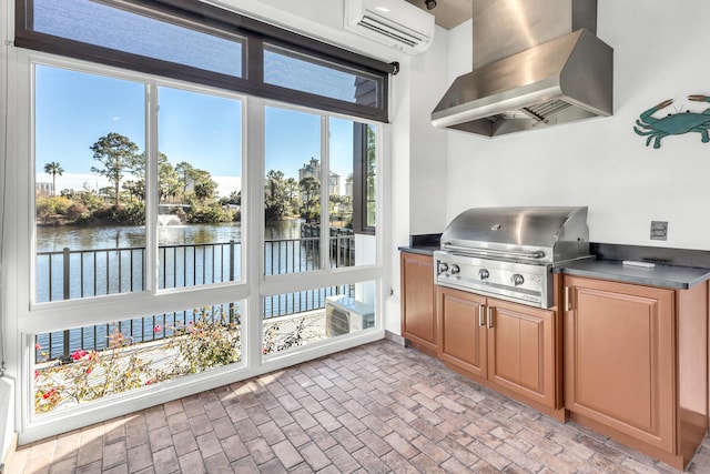 kitchen with island range hood, an AC wall unit, and a water view