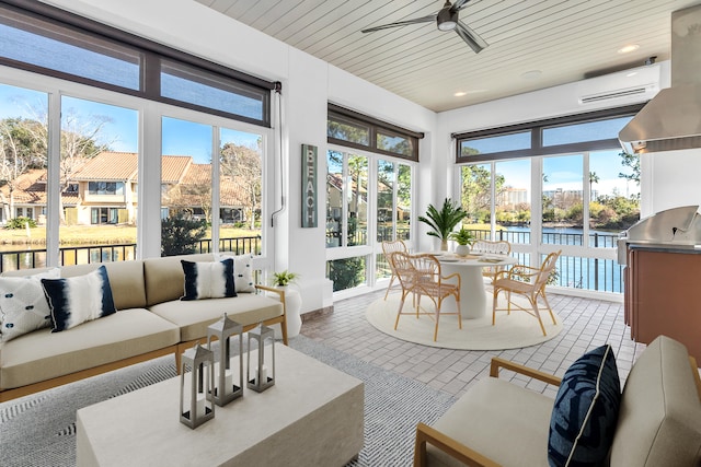 sunroom with wood ceiling, a water view, ceiling fan, and a wall unit AC