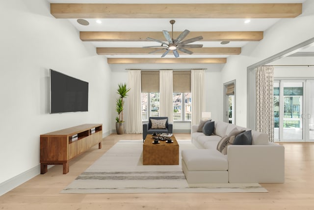 living room with light wood-type flooring, a healthy amount of sunlight, beam ceiling, and ceiling fan