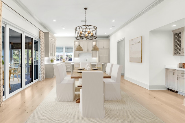 dining space with crown molding, light hardwood / wood-style flooring, and a chandelier