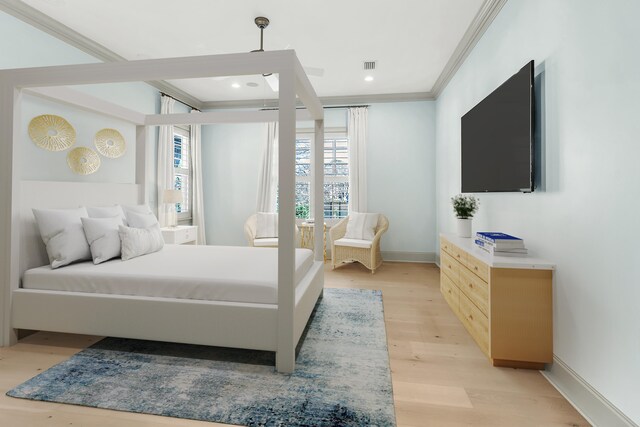 bedroom with ornamental molding and light hardwood / wood-style floors