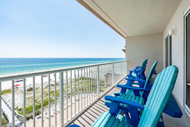 balcony featuring a water view and a beach view