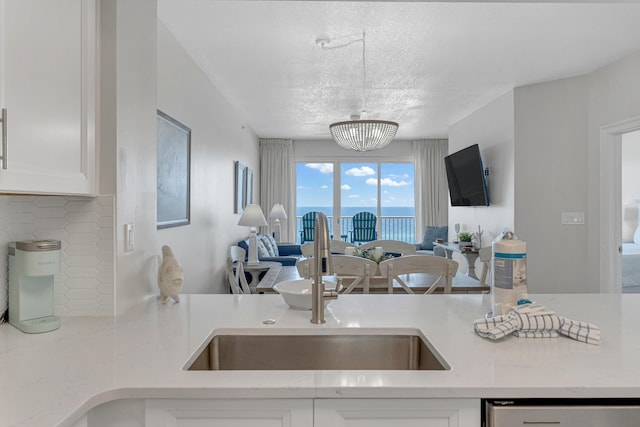 1111 Santa Rosa Blvd Unit 604, Fort Walton Beach, FL 32548 - kitchen featuring open floor plan, tasteful backsplash, a sink, and white cabinets
