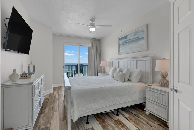 bedroom with light hardwood / wood-style floors, access to exterior, ceiling fan, and a textured ceiling