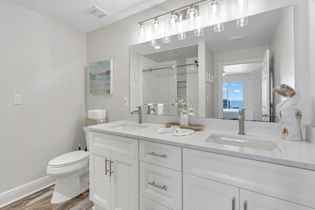 bathroom with vanity, hardwood / wood-style flooring, an enclosed shower, and toilet