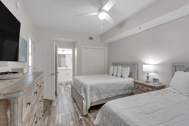 bedroom with a closet, wood-type flooring, ceiling fan, and ensuite bathroom