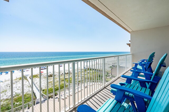 balcony featuring a water view and a beach view