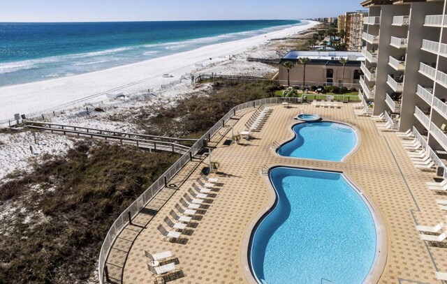 view of pool with a beach view, a patio, and a water view