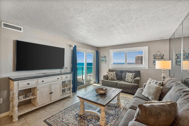 living room featuring a textured ceiling and light tile patterned floors