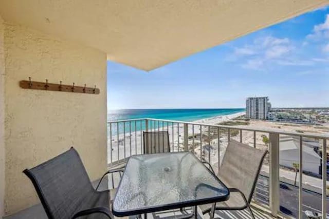 balcony featuring a water view and a beach view