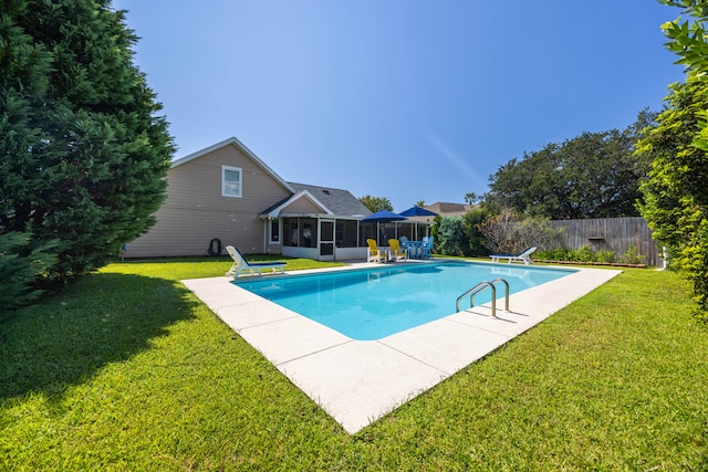 view of pool with a sunroom, a diving board, and a lawn