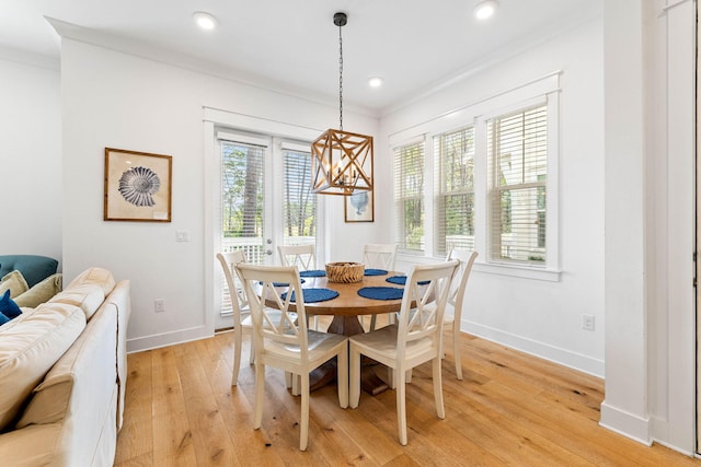 dining space featuring light wood-type flooring and ornamental molding