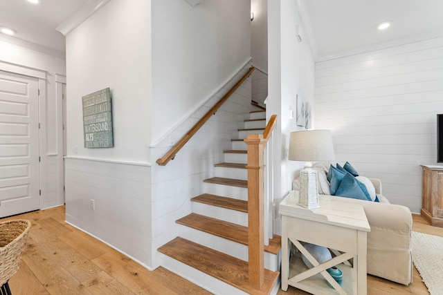 stairway featuring crown molding and hardwood / wood-style floors