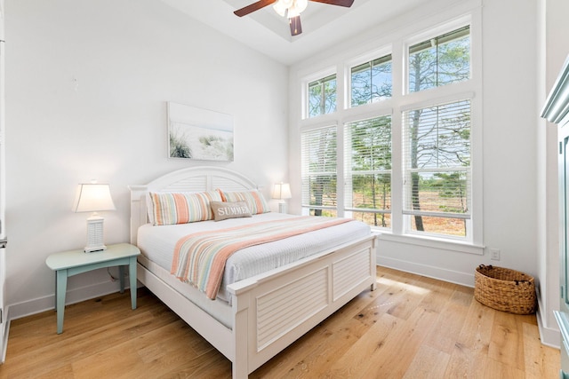 bedroom featuring light hardwood / wood-style flooring, multiple windows, and ceiling fan