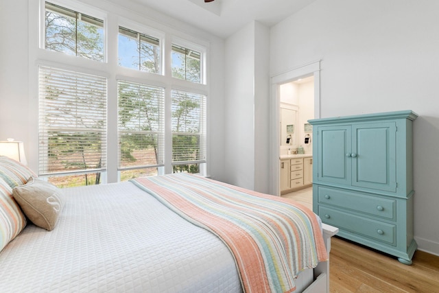 bedroom featuring light hardwood / wood-style flooring and connected bathroom