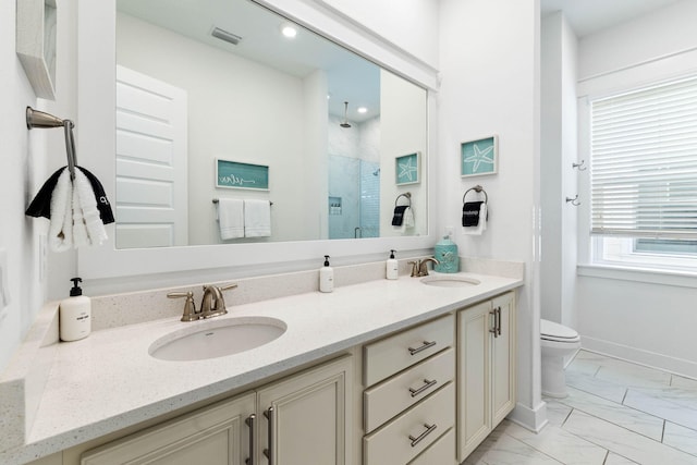 bathroom with vanity, toilet, and a shower with door