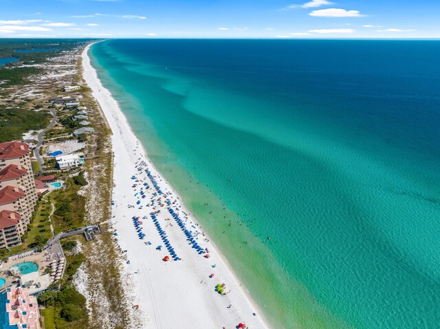 birds eye view of property featuring a water view and a beach view