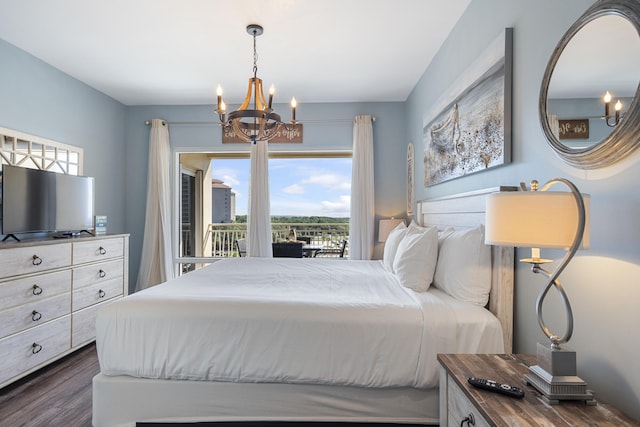 bedroom with dark hardwood / wood-style floors, a chandelier, and access to exterior