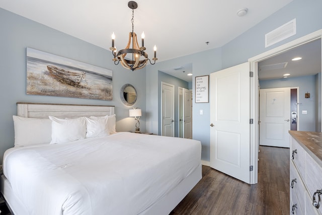 bedroom with a chandelier and dark wood-type flooring