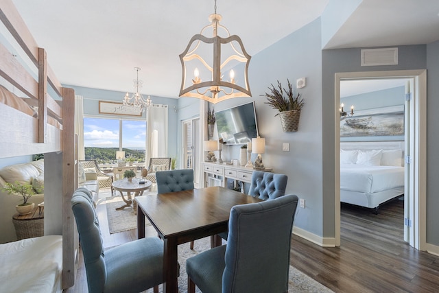 dining space featuring an inviting chandelier and dark hardwood / wood-style flooring