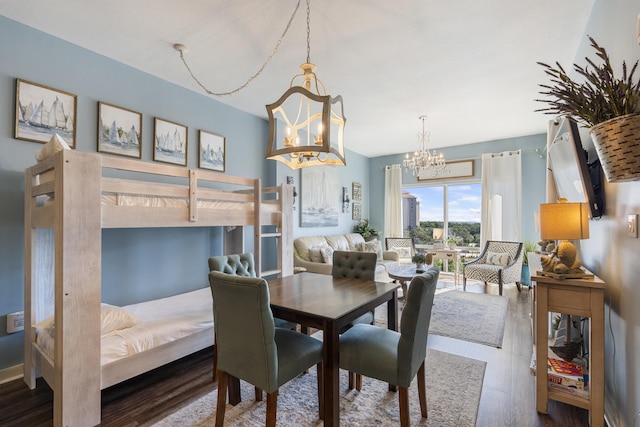 dining space with wood-type flooring and an inviting chandelier