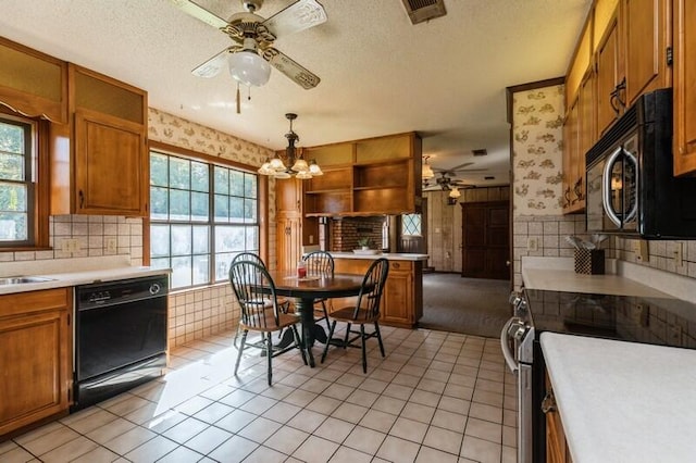 kitchen featuring pendant lighting, light tile patterned flooring, appliances with stainless steel finishes, and a healthy amount of sunlight