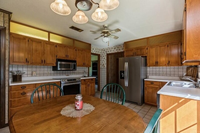 kitchen with stainless steel appliances, tasteful backsplash, sink, and light tile patterned floors