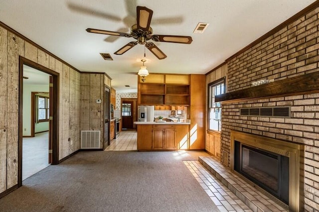 kitchen with light carpet, stainless steel refrigerator with ice dispenser, a fireplace, and crown molding