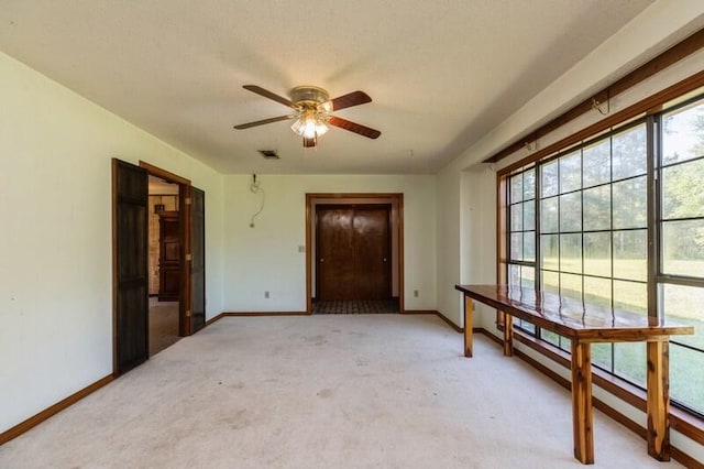 carpeted spare room featuring ceiling fan