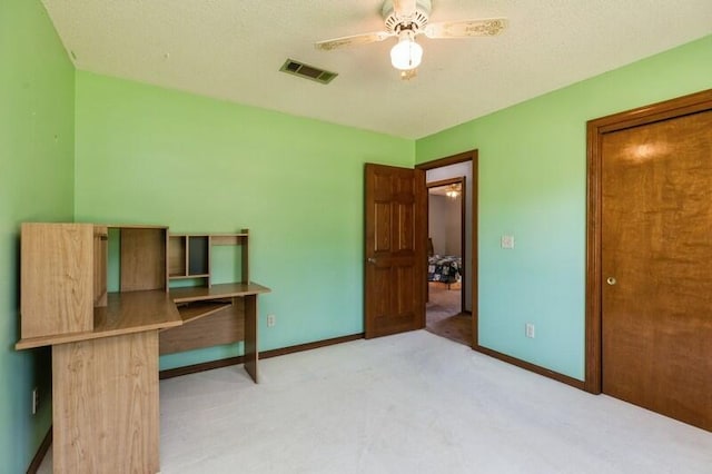 carpeted bedroom featuring ceiling fan and a textured ceiling