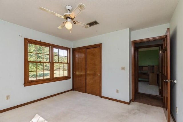 unfurnished bedroom featuring light carpet, a closet, and ceiling fan