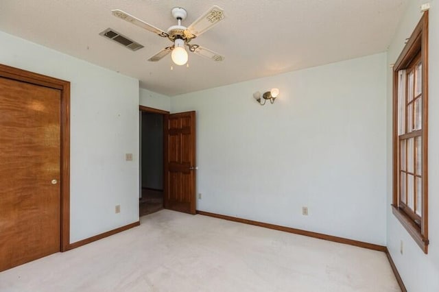 carpeted spare room featuring ceiling fan