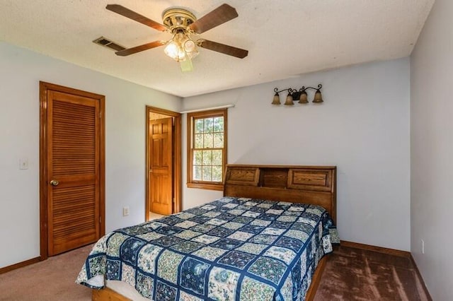 carpeted bedroom featuring ceiling fan and a textured ceiling