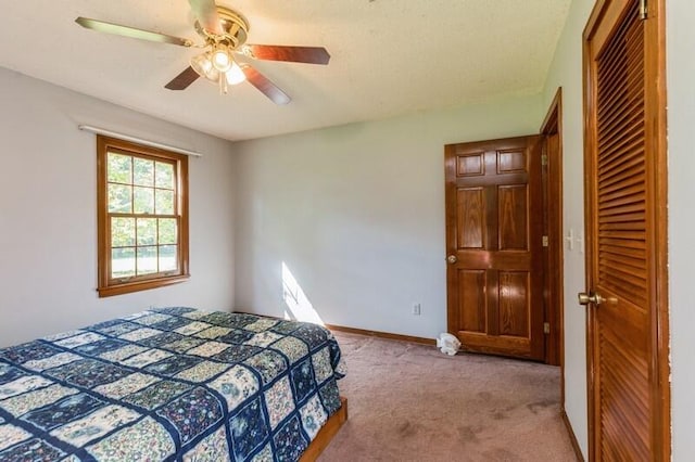 carpeted bedroom featuring a closet and ceiling fan