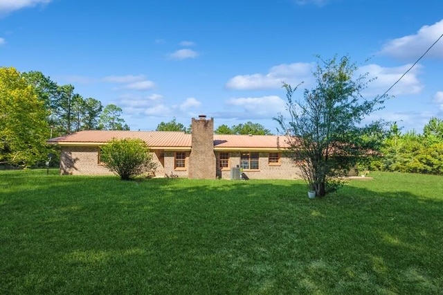 rear view of house featuring a lawn