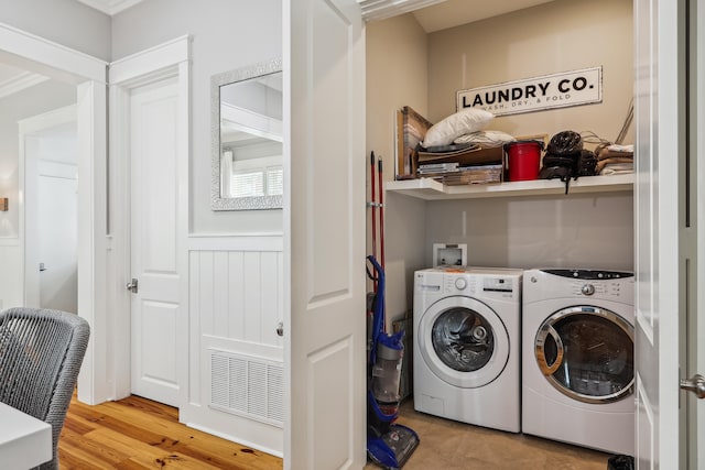 laundry area with separate washer and dryer, crown molding, and hardwood / wood-style floors