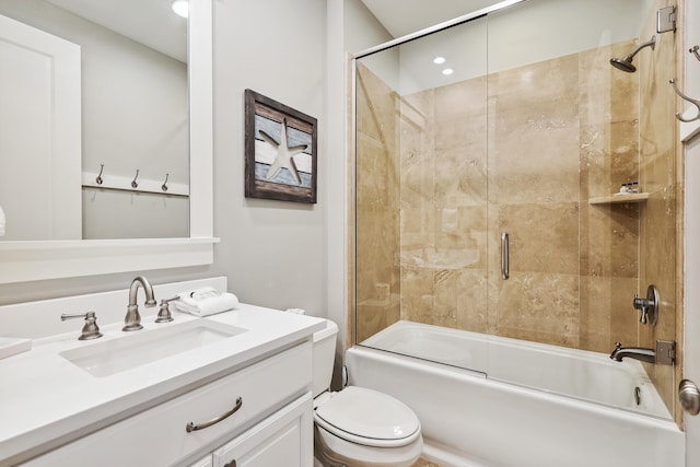 full bathroom featuring combined bath / shower with glass door, vanity, and toilet