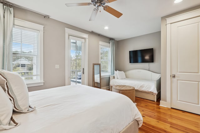 bedroom featuring ceiling fan, wood-type flooring, access to outside, and multiple windows