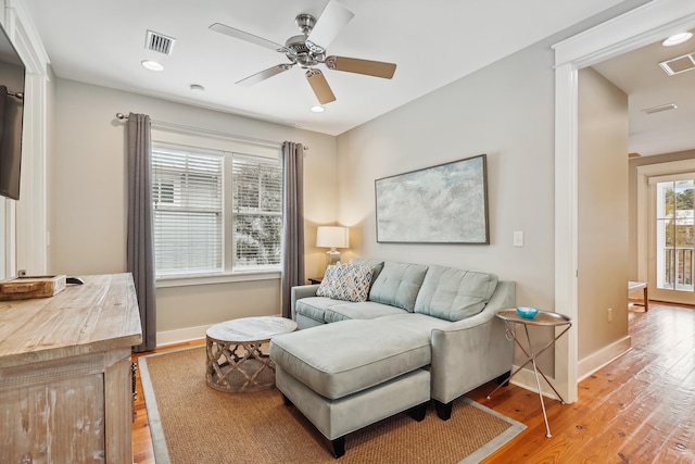 living room featuring ceiling fan and light hardwood / wood-style flooring