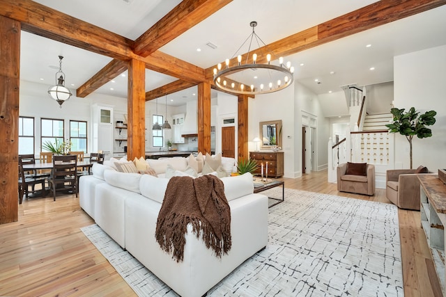 living room featuring a notable chandelier, light hardwood / wood-style flooring, and beam ceiling