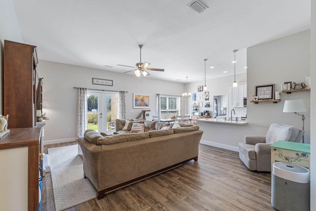 living room featuring french doors, ceiling fan with notable chandelier, and dark hardwood / wood-style flooring