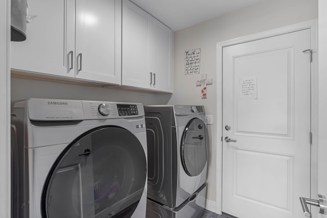 washroom featuring cabinets, hardwood / wood-style floors, and washer and clothes dryer