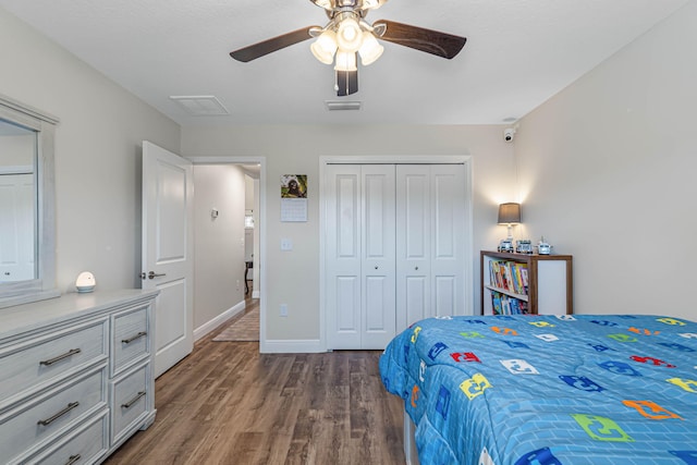 bedroom featuring dark wood-type flooring, a closet, and ceiling fan