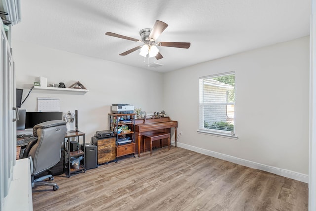 office with light hardwood / wood-style floors, a textured ceiling, and ceiling fan