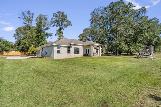 back of property with a playground and a lawn