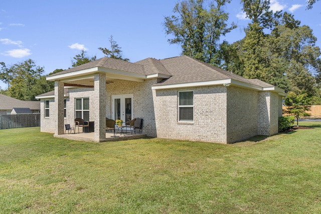 back of house featuring a patio area and a lawn