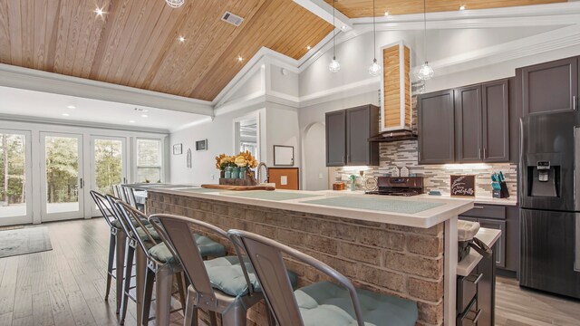 kitchen featuring wooden ceiling, dark brown cabinetry, lofted ceiling, and stainless steel appliances