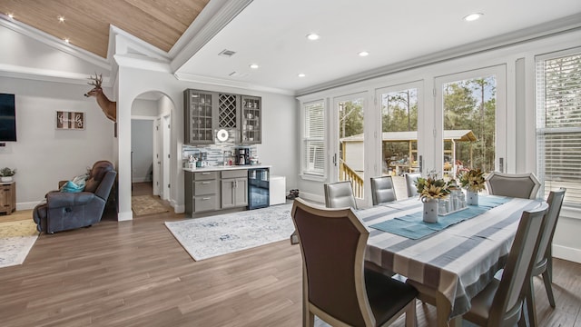 dining space featuring wooden ceiling, crown molding, light hardwood / wood-style floors, and lofted ceiling