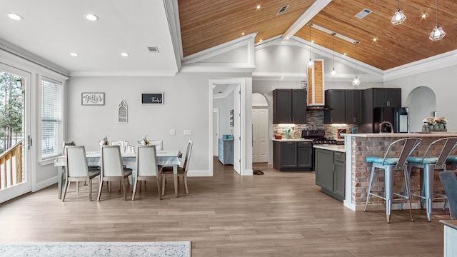 kitchen with a kitchen island with sink, wood ceiling, vaulted ceiling, and hardwood / wood-style flooring