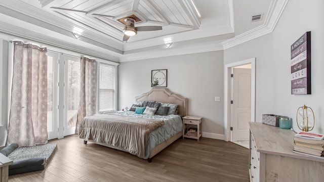 bedroom with ornamental molding, a tray ceiling, ceiling fan, and hardwood / wood-style floors